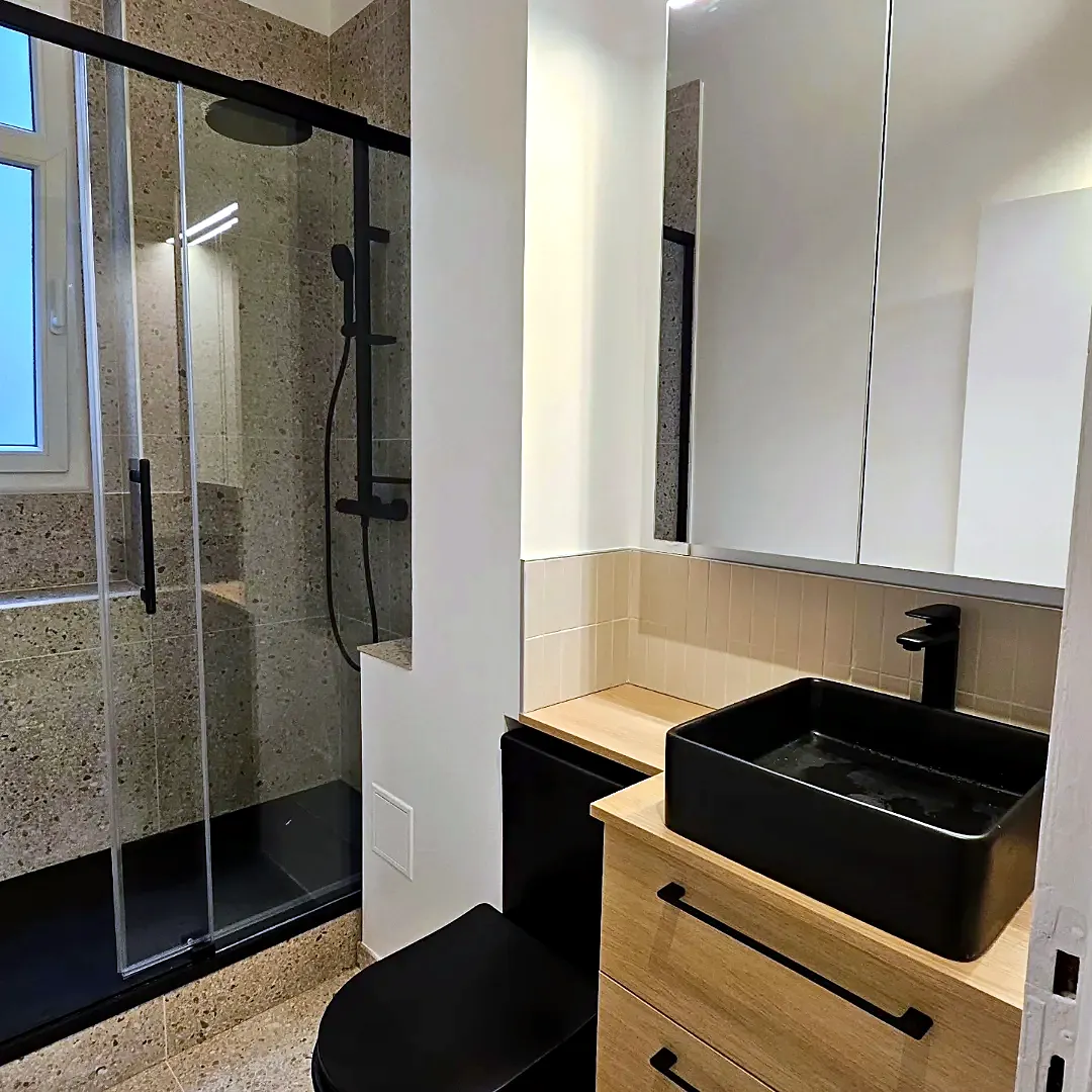 Salle de bains terrazzo, vasque noire et paroi de douche