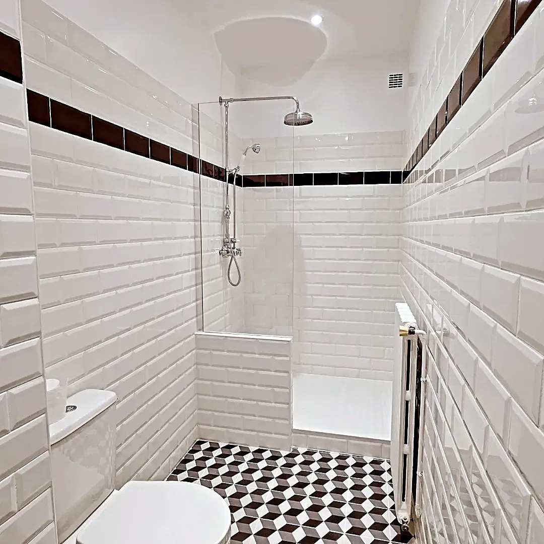 Douche avec carreaux métro et sol en cubes